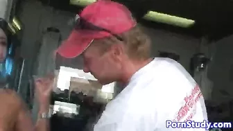Naked girl with black hair and mechanics fool around in garage