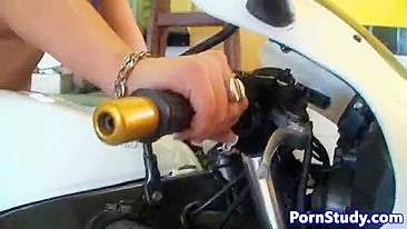Naked girl with black hair and mechanics fool around in garage