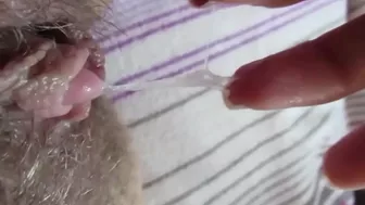 Horny wench pulls panties aside to play with big clit on the bed