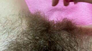 Belle with hairy bush touches big clit till achieving squirt orgasm