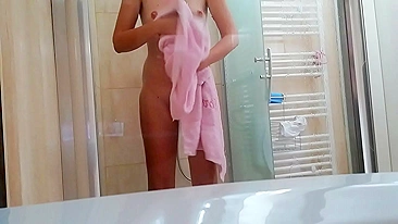 Slim girl washes her hairy bush while taking hot shower in the hotel