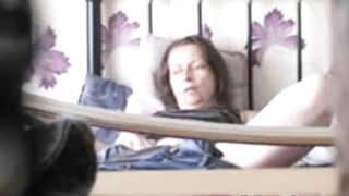 Black-haired mature caught masturbating on the bed being alone at home