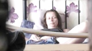 Black-haired mature caught masturbating on the bed being alone at home