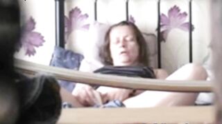 Black-haired mature caught masturbating on the bed being alone at home