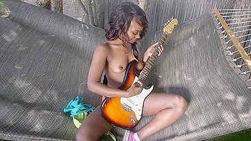 Ebony flaunts her perky XXX tits and plays the guitar in the hammock