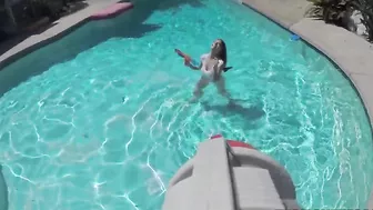 Chick fools around in pool with water gun and naked XXX body parts