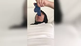 Blue XXX toy is inside mouth of Dubai mom in white top and colorful pants