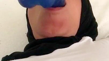 Blue XXX toy is inside mouth of Dubai mom in white top and colorful pants