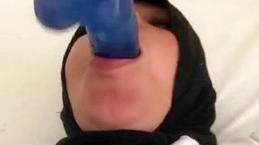 Blue XXX toy is inside mouth of Dubai mom in white top and colorful pants