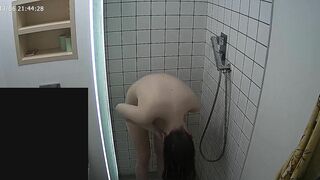 The caught sister continues having her shower unaware of the hidden camera