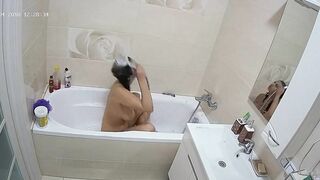 Curvy caught sister is getting wet in the bathtub while being caught on camera