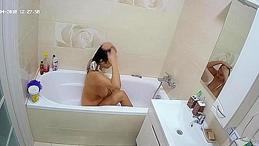 Curvy caught sister is getting wet in the bathtub while being caught on camera