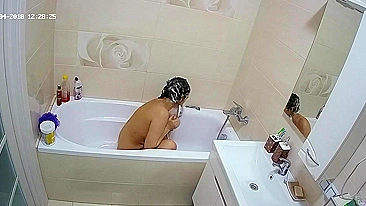 Curvy caught sister is getting wet in the bathtub while being caught on camera