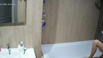 A tall woman talks on the phone before hopping in the tub in this caught sister