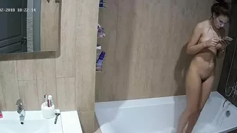 A tall woman talks on the phone before hopping in the tub in this caught sister