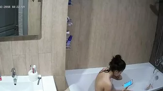 A tall woman talks on the phone before hopping in the tub in this caught sister