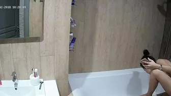 A tall woman talks on the phone before hopping in the tub in this caught sister