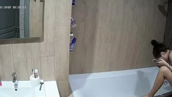 A tall woman talks on the phone before hopping in the tub in this caught sister