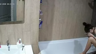 A tall woman talks on the phone before hopping in the tub in this caught sister