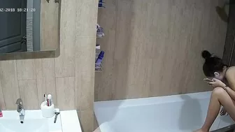 A tall woman talks on the phone before hopping in the tub in this caught sister