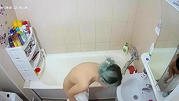 A caught sister with dyed hair is using the water to make her twat very wet