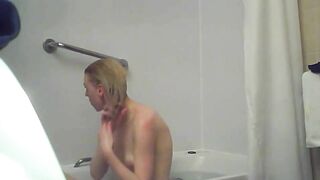 A blonde woman with a shaved pussy and a fit body is caught sister in the shower