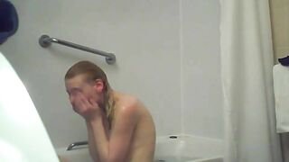 A blonde woman with a shaved pussy and a fit body is caught sister in the shower