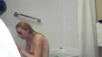 A blonde woman with a shaved pussy and a fit body is caught sister in the shower