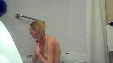 A blonde woman with a shaved pussy and a fit body is caught sister in the shower