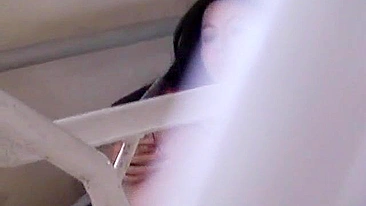 Hot Japanese babe pleasures herself while being watched by a voyeur.