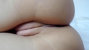 A close-up shot of a shaved pussy being masturbated.