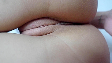 A close-up shot of a shaved pussy being masturbated.