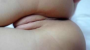 A close-up shot of a shaved pussy being masturbated.