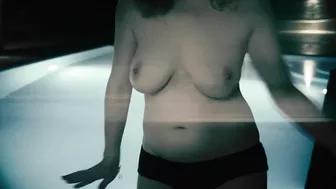 Redheaded girl dancing nude in rain with big natural breasts.