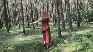 Redhead teases by flashing big boobs while peeing in forest.