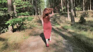 Redhead teases by flashing big boobs while peeing in forest.