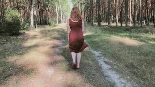 Redhead teases by flashing big boobs while peeing in forest.