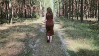 Redhead teases by flashing big boobs while peeing in forest.