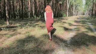 Redhead teases by flashing big boobs while peeing in forest.