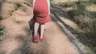 Redhead teases by flashing big boobs while peeing in forest.