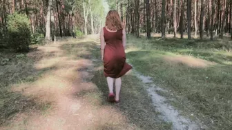 Redhead teases by flashing big boobs while peeing in forest.