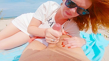Red-haired woman flashes and performs oral sex on beach before receiving a large cum shot in public.