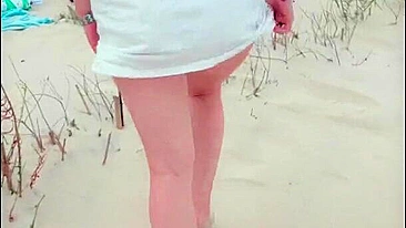 Redhead in white dress flashes and blows at risky public beach; cumshot ensues.