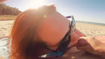 Sexy redhead gives public beach blowjob with sunglasses on.