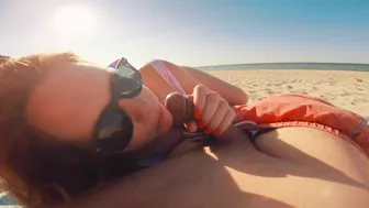 Sexy redhead gives public beach blowjob with sunglasses on.