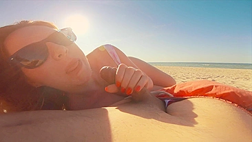 Sexy redhead gives public beach blowjob with sunglasses on.