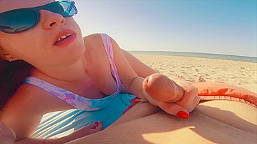 Sexy redhead gives public beach blowjob with sunglasses on.