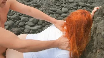 Red-haired woman standing on beach having sex and cream pie, risqué.
