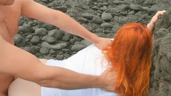 Red-haired woman standing on beach having sex and cream pie, risqué.
