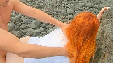 Red-haired woman standing on beach having sex and cream pie, risqué.